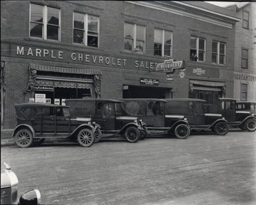 Exterior of Marple Chevrolet Dealership; trucks and automobiles are parked in front; located on corner of University Avenue and Walnut Street.<br />