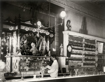 Interior of drug store (probably Ream's Drug Store) with soda fountain on 304 High Street, Morgantown; the counterman is Harry Selby.