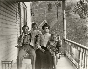 Family of four sitting on a porch swing, Morgantown.<br />