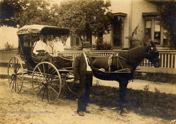 Group portrait of McKean Family with their horse and carriage prior to participating in a parade in Beckley.  From left to right:  Gertie (Beasley) McKean, son Clay, daughter Mae, and Sam McKean.