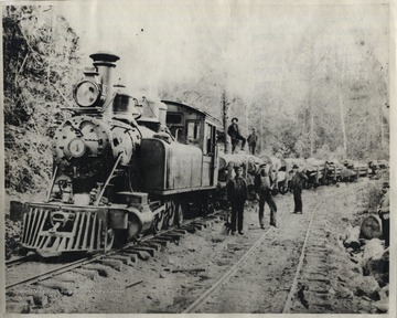 Portrait of Lumber Workers on and beside a train. On Train-L-R 1.- 2.- On Ground-L-R 1. Ernest C. Sine 2.- 3.-; O. Homer Floyd Fansler, Hendricks, W.Va.