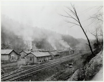 Wooden buildings next to train tracks.  