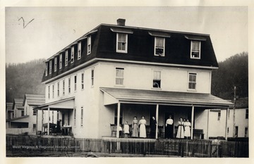 Group of people standing on the porch of the Meadow River Lumber Company Boarding House, Rainelle, W.V.