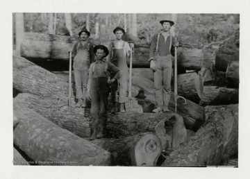 Four men standing on logs.  Preston Moore on left.   
