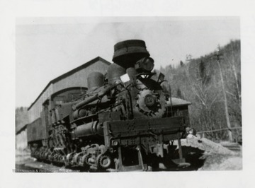 Train engine with building behind it.