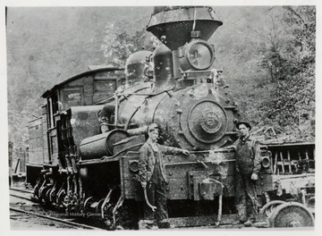 Train engine with two workers in front of it.  