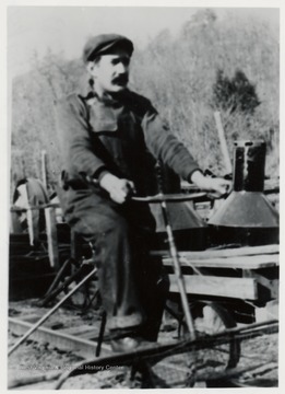 Man rides speeder on railroad tracks.