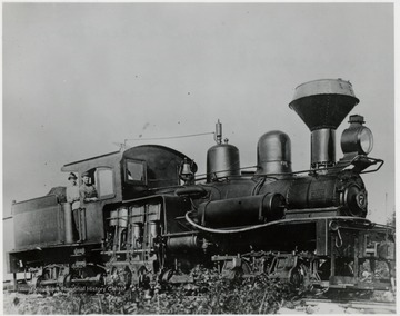 Shay No. 7 train engine with two men in the cabin.