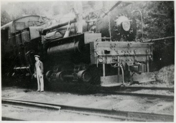 Train engine with man standing beside it.