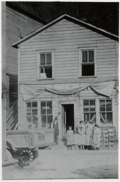 John Reda's grocery store with a man and five children standing in front of it.  