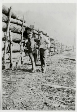 Paul James and Ray McClelland pose in front of loaded log cars.