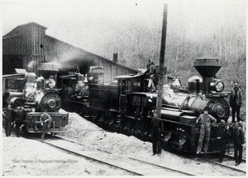 Men standing in front, on, and around the locomotives.