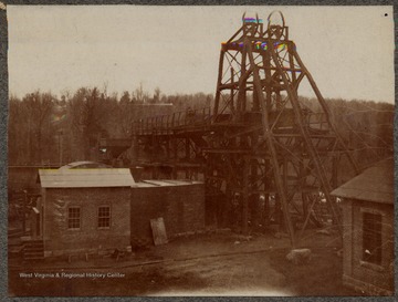 A hoist mechanism for a shaft coal mine next to several buildings at a mine in an unknown location, likely in West Virginia.