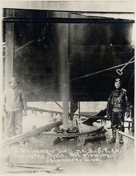 Oil flows into the air between two oil workers.