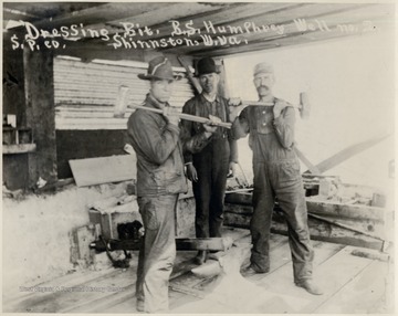 Three men working on oil equipment.  