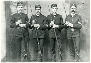 Four soldiers from the Zickafoose family pose for a portrait holding muzzle-loading rifles with bayonets fixed.