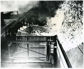 Caption on back reads, 'Coke Plants, White-hot coke being pushed from a by-product coke oven at United States Steel Corporation's Clairton, Pa. Works. The car into which the coke is being pushed goes to a quenching tower where it is cooled. Located in the great Pittsburgh steel-producing area, the Clairton by-product coke plant is one of the largest in te world, with a battery of more than 1,500 coke ovens, and has a daily consumption capacity of 30,000 tons of coal. Undated photo courtesy U.S. Steel.; Stamp: Bituminous Coal Institute, 320 Southern Bldg. Washington 5, D.C.