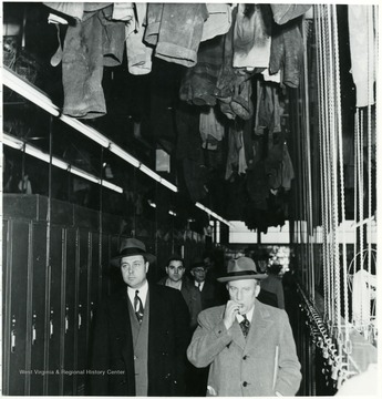 Men walking through locker room during a Consolidation Coal Co. Inspection trip.