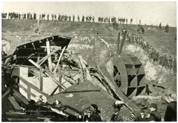 People standing amongst the wreckage of the fan and boiler houses at the entrance to Monongah Mine. 