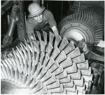 Mechanic working on what appears to be a turbine.