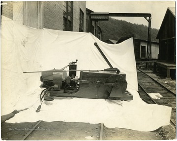 Piece of machinery sitting outside on a white sheet.