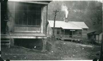 Unidentified man standing on porch of company structure on the left. The sign on the building center left reads, "State Police Detachment".