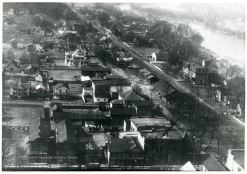 "This is an excellent view of the principal business district of the Town of Alderson at the turn of this century. Note prominence of two large railroad stations 'passanger and freight' and the long freight yard on down the tracks from the passanger station. On the west side of Monroe Street 'foreground' we see from left to right these stores: #1-J.M. Alderson, Gen Merch. '1888-1930', #2- Shanklin [and] Co., Gen Merch. 1900-1904, #3- E.D. Jeffries 'later W.J. Hancock', #5 Corner- First National Bank '1901--'==turning corner from bank: #2 T. M. Reynolds- Gen Merch. '1890's-1906', #3 'brick bldg'- J. Orr Nickell Drug store, #3b. 'same bldg' Greenbrier Valley Bank '1884-1909', Post Office and 2 small confectionaries. #7 Annex to Monroe Hotel with Hardware of G.W. Graves in bottom floor 'Hotel:1872-1935', Hardware '1879-1925', #8 Monroe Hotel, main bldg.-J.M. Trice barber shop, Lobban Bros.,Furniture '1901-1909,1909--', other small stores, residences; far right: Alderson Hotel."