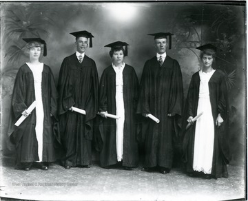 Group portrait of five graduates in caps and gowns.