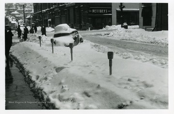 People are walking on Monroe and Adams Streets in Fairmont, West Virginia during the big snow storm of 1950.