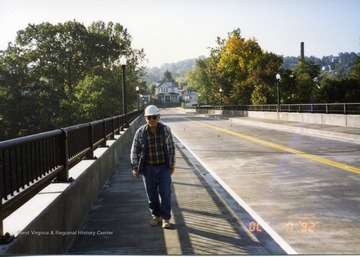 Construction worker walking across completed South Park bridge. 