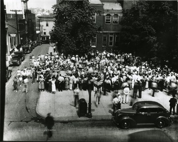 Crowd of people standing in the Courthouse Square. 