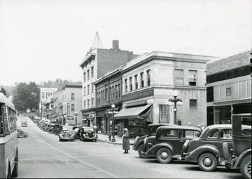 A woman waits to cross High Street at the corner of High Street and Fayette Street in Morgantown, W. Va. 