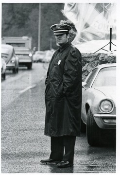 Police officer, Ralph D. Chapman, stands next to the road.