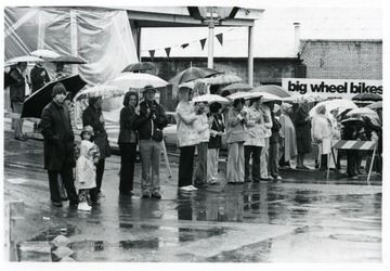 People watch the parade from under their umbrellas.