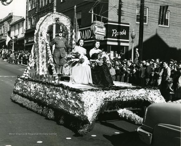 Two ladies in their dresses sit atop the Labor Temple Float in the Labor Day Parade. 