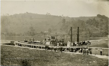 Passengers gathered on the deck of a steamboat on the Monongahela River.