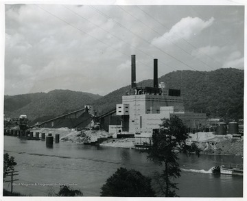 'The new 400,000 kilowatt Kanawha River Plant of Appalachian Electric Power Company at Glasgow, West Virginia, as it appears from the river side. The first of two 200,000 kilowatt units is now in service. The second unit is scheduled for completion late this fall.'
