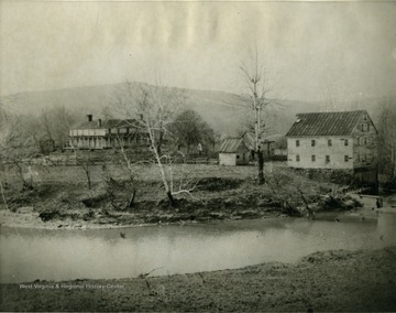 A view of Jackson's Mill, some buildings to the left of the mill, and the river.