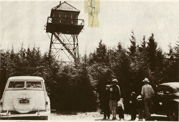 Family looks at Gaudinier Knob Fire Tower at 4,440 feet elevation in Monongahela National Forest in W. Va.