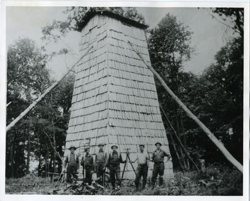 Six men are standing in front of a Fire Tower which is located on either Turkeybone Mountain or Sharps Knob during the survey of Monogahela National Forest Boundries.