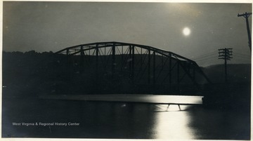 Full moon shining over the Cheat River and bridge.