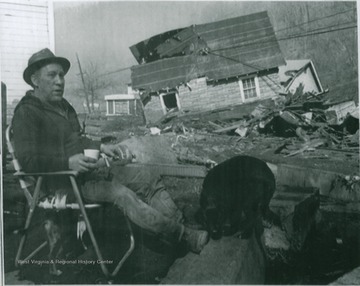 James Chapman sits with his dog in front of his demolished home three days after the Pittston Coal Company's coal slurry impoundment dam broke, killing 125 people and leaving thousands homeless. Four days before the disaster, the dam had been declared "satisfactory" by federal inspectors.