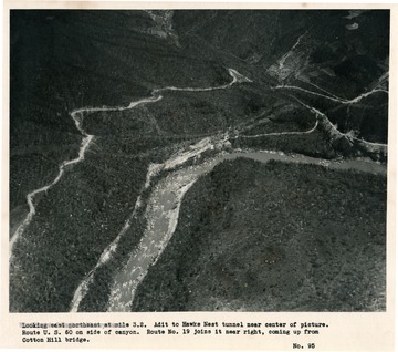 'Looking east northeast at mile 3.2.  Adit to Hawks Nest tunnel near center of picture.  Route U.S. 60 on side of canyon.  Route No. 19 joins it near right, coming up from Cotton Hill bridge.'