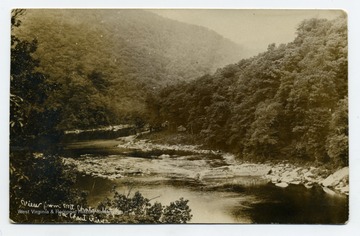 The photograph was taken from the east bank directly opposite Maple Run and the town of Rockley. Quarry Run empties into the Cheat at the bend in the river (left center). During the operation of the Cheat Iron Works(early 19th century), a saw mill and a boat yard were located close to the mouth of Quarry Run. Lumber from this mill was used to build flat boats to transport iron to markets. Information from A&M 3848; Grafton, A. Edwin. Paper.