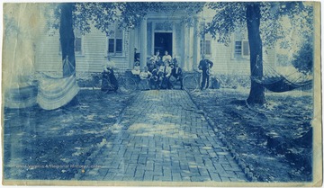 Long view showing hammocks and a man and a woman with bicycles on each side of the group.
