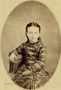 Young girl in a plaid dress. She is unidentified. 