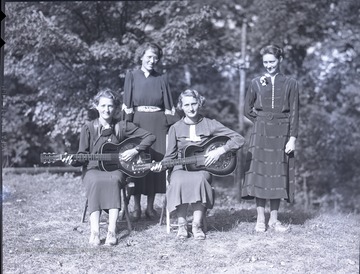 Group portrait of four unidentified 4-H members, two with instruments.