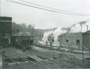 Loaded Baltimore & Ohio Rail Cars stand across from the unidentified workers and the ovens operated by Elkins Coal and Coke Company. 