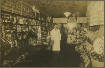 A store clerk poses in the interior of a grocery shop.