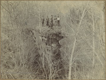 Five unidentified man stand by the edge of the cliff. 